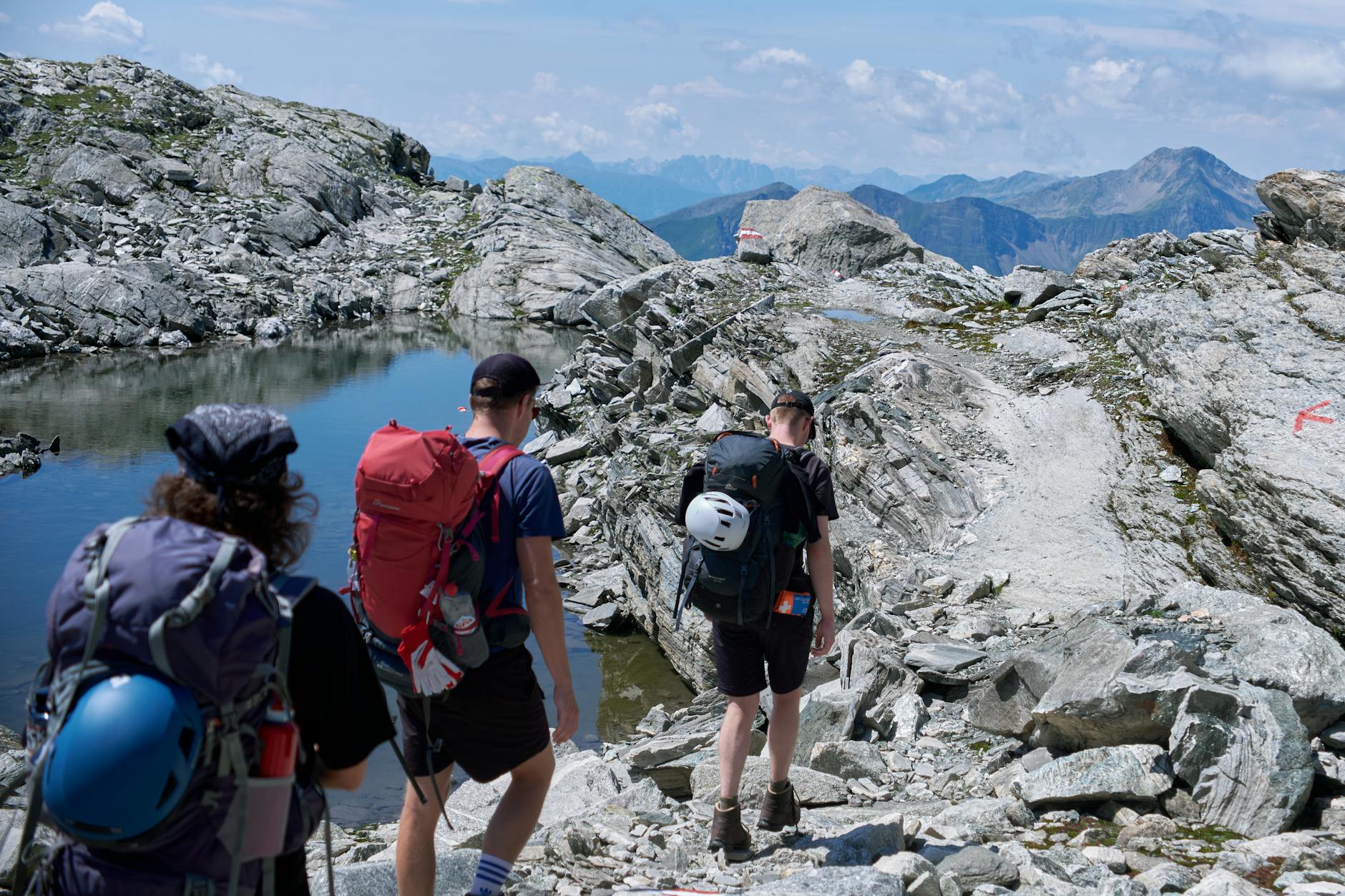 Pasmo Alp w pigułce – przewodnik po najpiękniejszych szlakach wysokogórskich Turyści wędrują skalistym szlakiem w austriackich Alpach