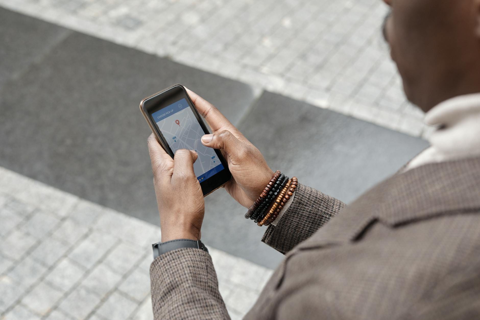 Osoba na miejskiej ulicy sprawdza mapę zagrożeń w telefonie