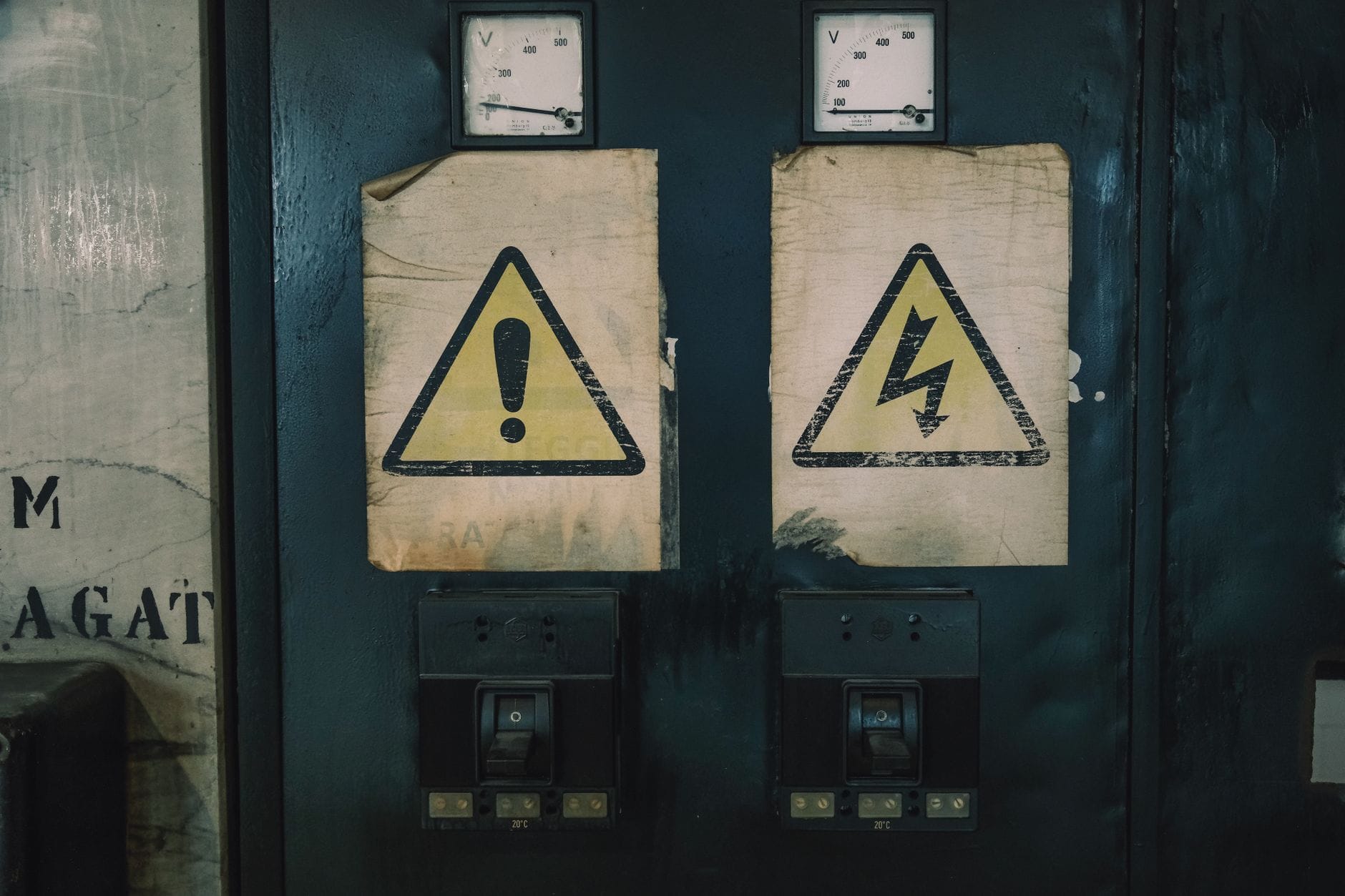 Zbliżenie na znaki ostrzegawcze na starej rozdzielnicy elektrycznej